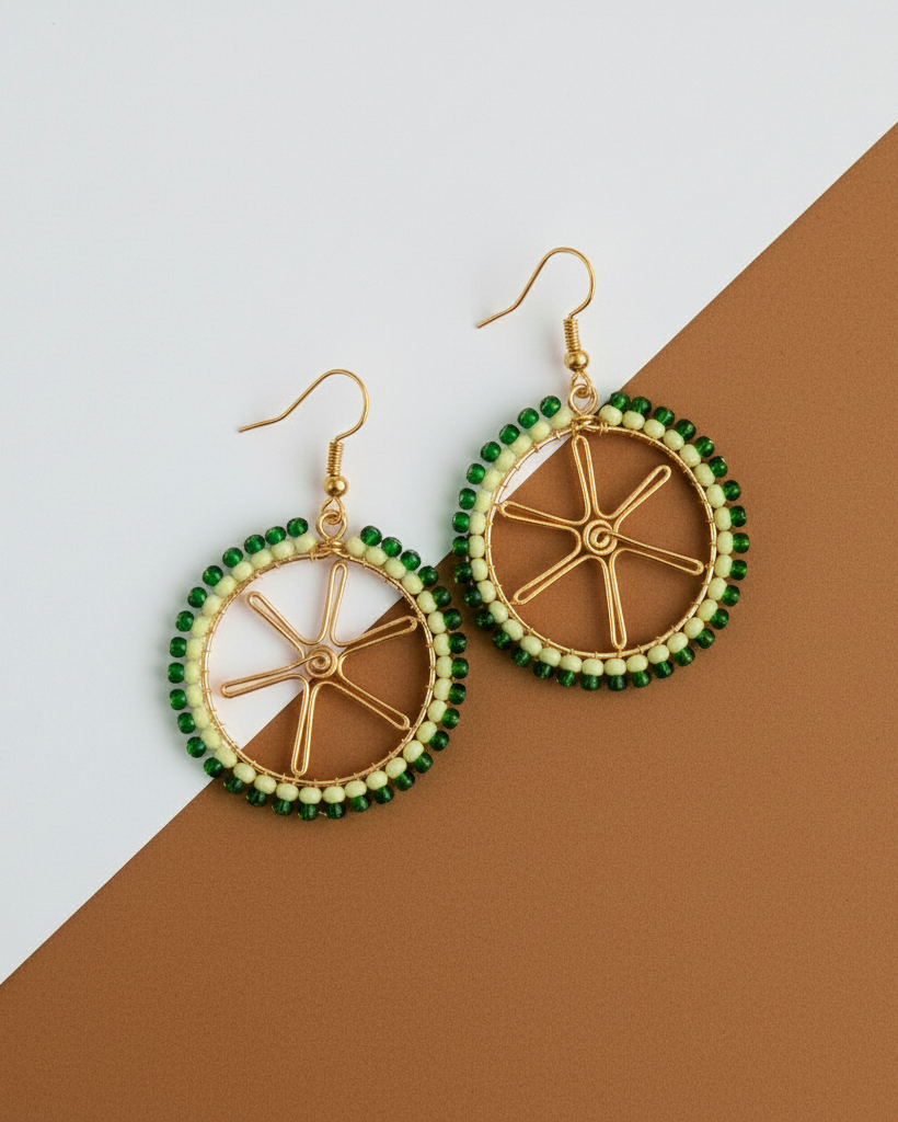 Pair of lime shaped Kawami earrings with green and gold design on a two-tone background