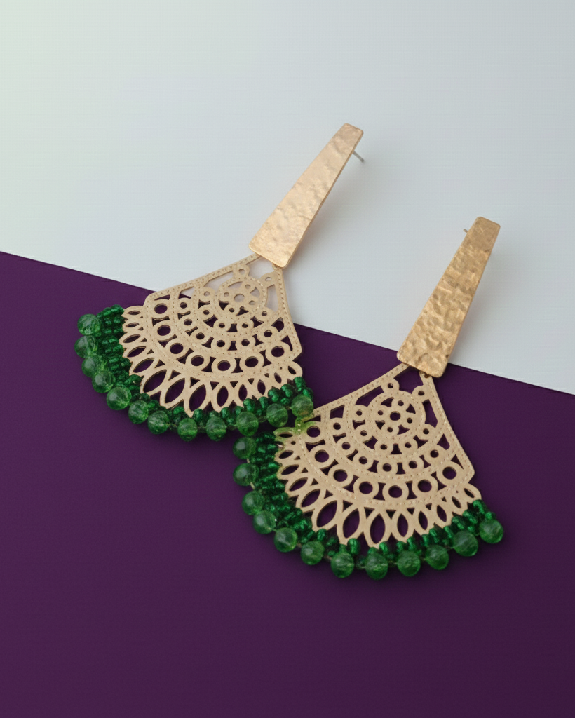Gold and green Kawami earrings on a purple and white background