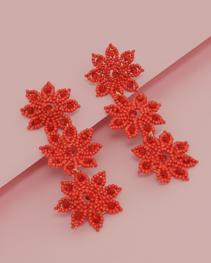 3 Star-Shaped in red color Kawami earrings on a pink background
